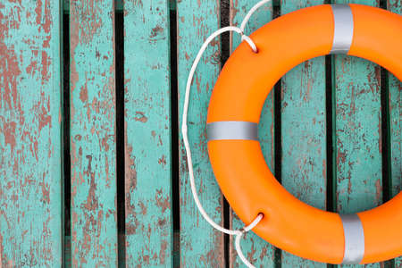 Orange life buoy on turquoise wooden background, top view. Space for textの写真素材