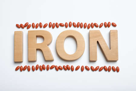 Word Iron and pills on white background, top view. Anemia conceptの写真素材