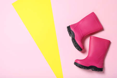 Bright pink rubber boots on color background, top view. Space for textの写真素材