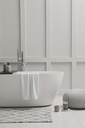 Modern ceramic bathtub near white wall indoorsの写真素材