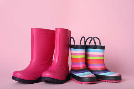 Two pairs of rubber boots on pink backgroundの写真素材
