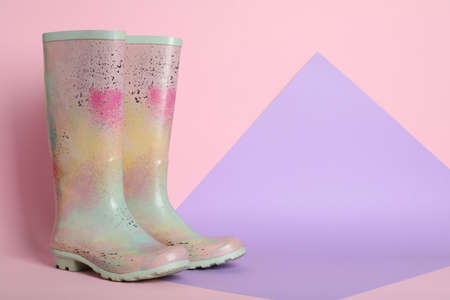 Pair of rubber boots on color background. Space for textの写真素材