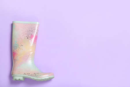 Colorful rubber boot on violet background, top view. Space for textの写真素材