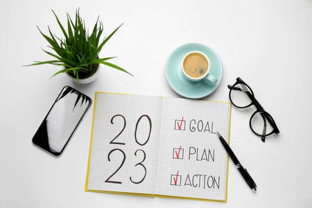 Flat lay composition of notebook with text 2023 Goal, Plan, Action on white background. New year resolutionsの写真素材