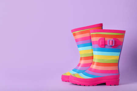 Pair of striped rubber boots on violet background, Space for textの写真素材