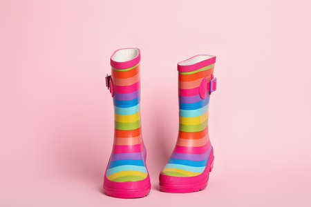 Pair of striped rubber boots on pink backgroundの写真素材