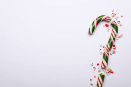 Broken sweet Christmas candy cane on white background, top view. Space for textの写真素材