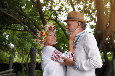 Happy mature couple in Ukrainian national clothes outdoors
