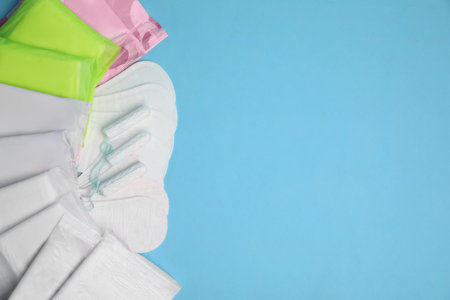 Menstrual pads, tampons and pantyliners on light blue background, flat lay. Space for textの写真素材