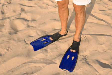 Man in blue flippers on sand, closeup viewの写真素材