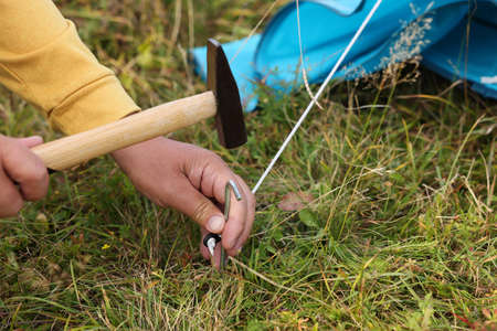 Man setting up camping tent outdoors, closeupの写真素材
