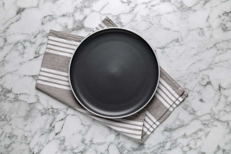 New dark plate and napkin on white marble table, top viewの写真素材