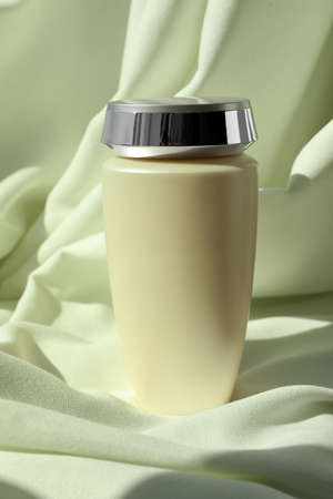 Bottle of hair care cosmetic product on light green fabricの写真素材
