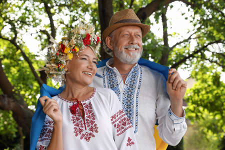 Happy mature couple with national flag of Ukraine outdoorsの写真素材