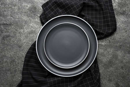 New dark plates and napkin on gray table, top viewの写真素材