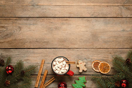 Flat lay composition of delicious hot chocolate with marshmallows and Christmas decor on wooden...