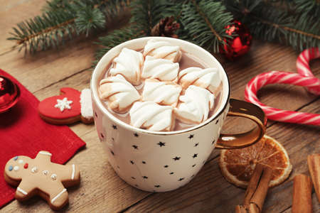 Delicious hot chocolate with marshmallows and Christmas decor on wooden table
