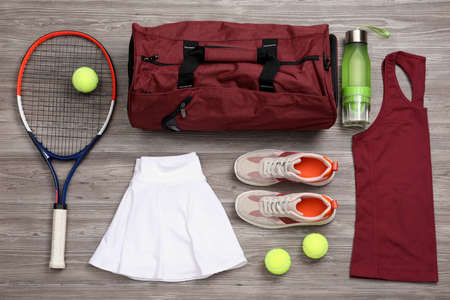 Sports bag and tennis equipment on wooden background, flat layの写真素材