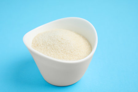Gelatin powder in bowl on light blue background, closeupの写真素材