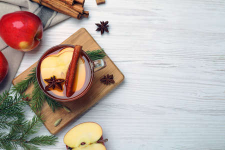 Aromatic hot mulled cider on white wooden table, flat lay. Space for textの写真素材