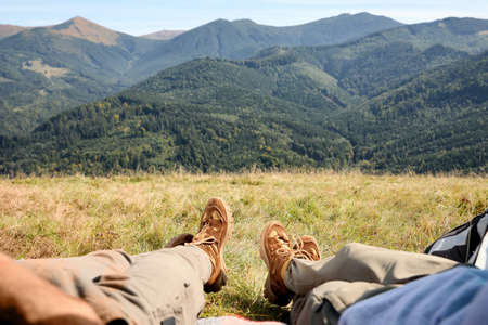 Couple lying on grass in mountains, closeup