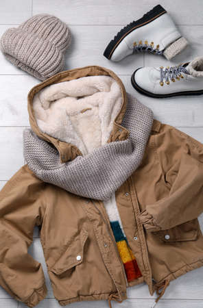Winter fashion. Layout with women's outfit on white wooden background, top view