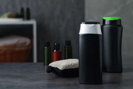 Bottles of shower gel and sponge on gray table in bathroom, space for textの写真素材