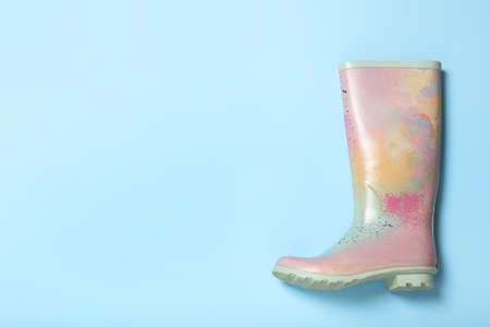 Colorful rubber boot on light blue background, top view. Space for textの写真素材