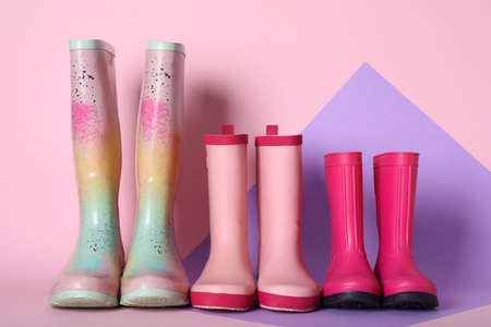Three pairs of rubber boots on color backgroundの写真素材