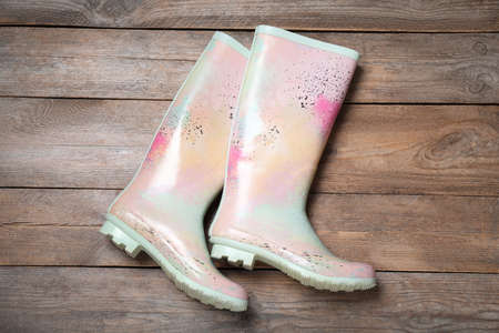 Pair of colorful rubber boots on wooden background, top viewの写真素材