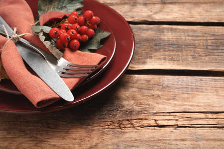 Festive table setting with ashberries on wooden background, closeup. Space for textの写真素材