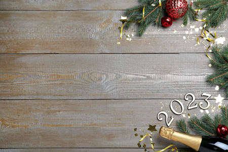 Happy New Year 2023! Flat lay composition with bottle of sparkling wine on wooden table, space for...