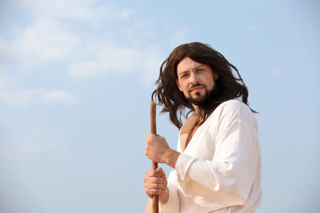 Jesus Christ with stick against blue skyの写真素材