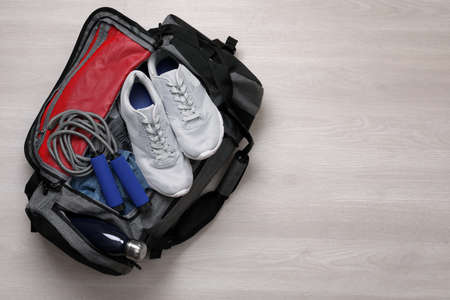 Gym bag with sports equipment on wooden background, top viewの写真素材