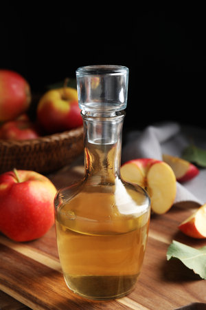 Natural apple vinegar and fresh fruits on wooden tableの写真素材