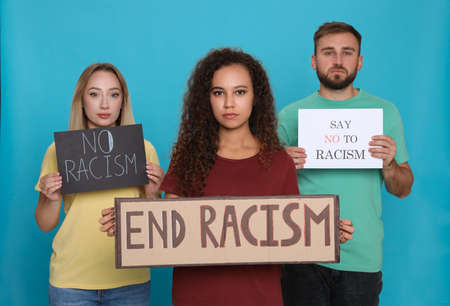 Group of people holding signs on light blue background. Racism conceptの写真素材