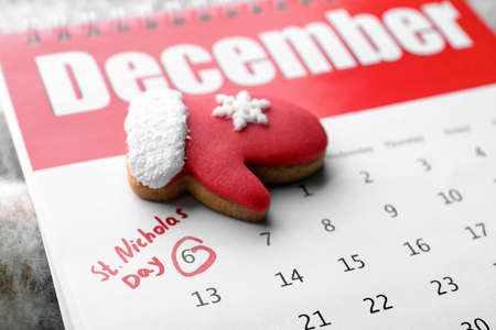 Saint Nicholas Day. Calendar with marked date December 06 and glove shape gingerbread cookie,...
