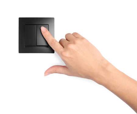 Woman pressing light switch on white background, closeupの写真素材