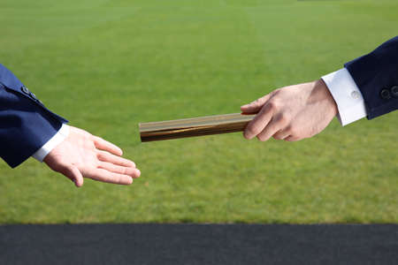 Businessman passing baton to his partner outdoors, closeupの写真素材