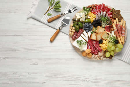 Different tasty appetizers on white wooden table, flat lay. Space for text