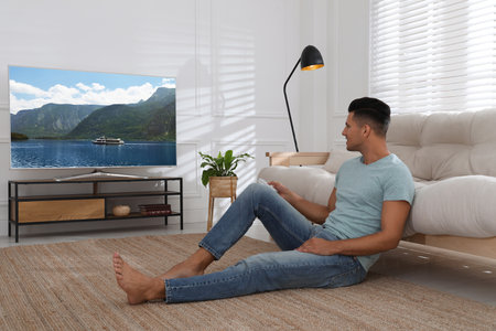 Man watching television at home. Living room interior with TV on stand