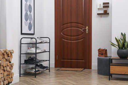 Shelving unit with shoes near white wall in hallの写真素材