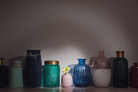 Vase with flower among empty ones on wooden table. Diversity conceptの写真素材