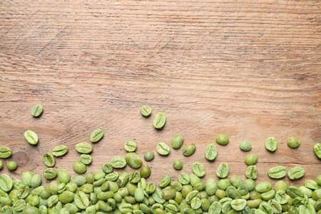 Many green coffee beans on wooden table, flat lay. Space for textの写真素材