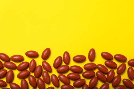 Many pills on yellow background, flat lay with space for textの写真素材
