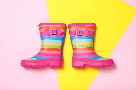 Pair of striped rubber boots on color background, top viewの写真素材