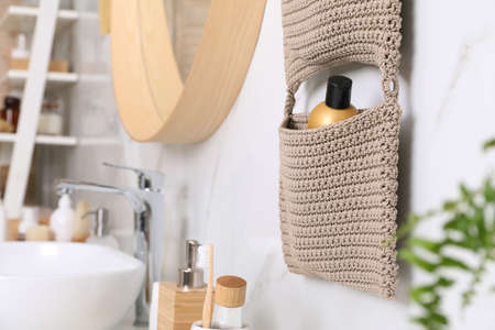 Storage with cosmetic bottle hanging on white marble wall in bathroom. Stylish accessoryの写真素材