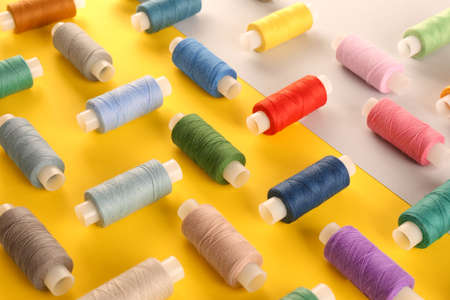Set of different sewing threads on color backgroundの写真素材