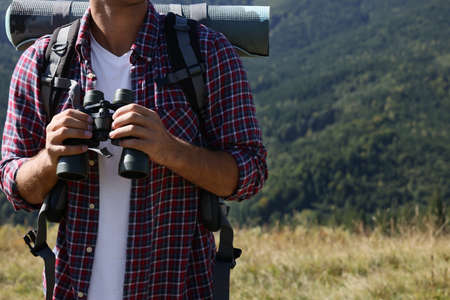 Tourist with hiking equipment and binoculars in mountains, closeupの写真素材