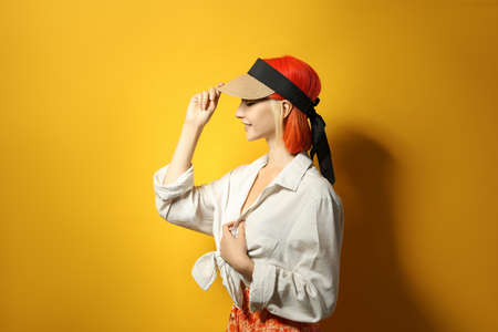 Beautiful young woman with bright dyed hair on orange backgroundの写真素材